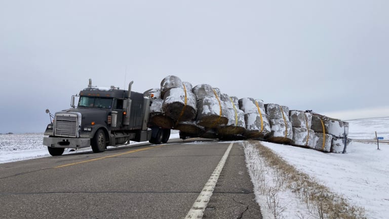 Photos: Semi hauling dozens of hay bales tips, blocking highway