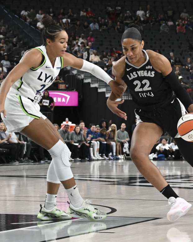 Sep 4, 2025; Las Vegas, Nevada, USA; Las Vegas Aces center A'ja Wilson (22) drives past Minnesota Lynx forward Napheesa Collier (24) in the first quarter of their game at T-Mobile Arena.
