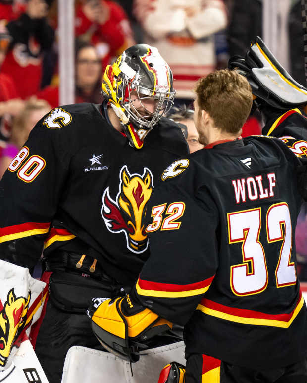 Calgary Flames goaltenders Daniel Vladar (80) Dustin Wolf celebrate after a shootout victory over the Minnesota Wild at Scotiabank Saddledome in Calgary, Alberta, on Nov. 23, 2024.