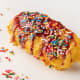 Handmade ice cream bar covered with a crispy corn flake coating, deep-fried, drizzled with raspberry and blueberry sauces, and topped with sprinkles. (Vegetarian)At Snack House, located in the Warner Coliseum, south side