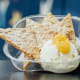 Lemon sandwich cookies deconstructed into four large tortilla chips made from a blend of cookies and corn, served with creamy-center-of-the-cookie cream dip topped with lemon curd.At Blue Moon Dine-In Theater, located on the northeast corner of Carnes Avenue and Chambers Street