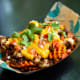 Sweet potato waffle fries topped with cheese curds, Beyond chorizo sausage, turmeric gravy, pico de gallo and fresh cilantro. (Vegetarian)At The Blue Barn, located at West End Market, south of the History &amp; Heritage Center