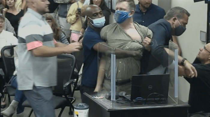 The suspect, the unmasked man on the right of the picture, was charged Thursday with both assault and disorderly conduct.