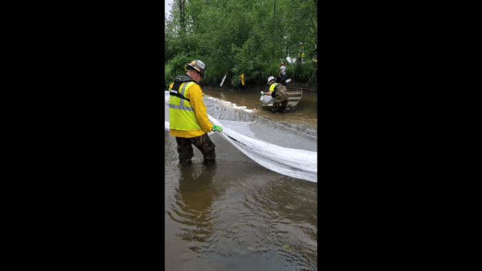 A screengrab from video showing workers at the site of an inadvertent discharge in the Willow River.