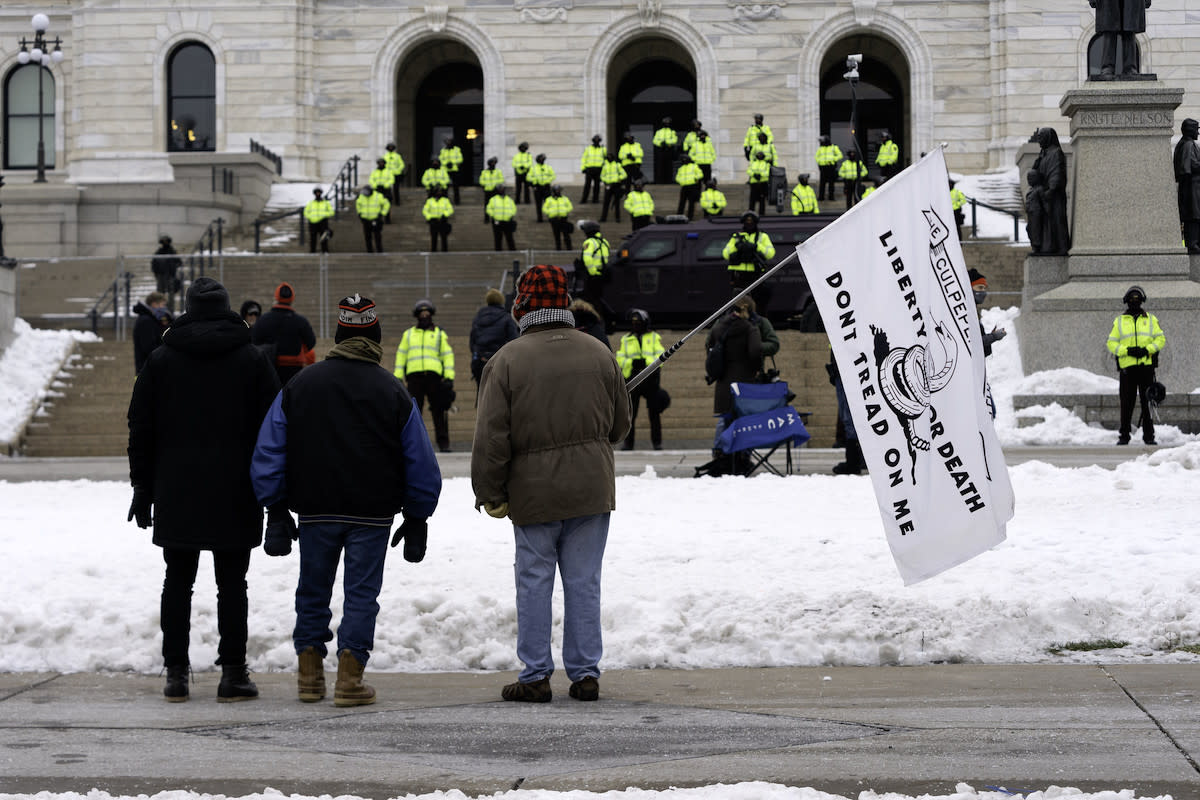 A protester holding a flag outside the Minnesota State Capitol on Sunday, Jan. 17.