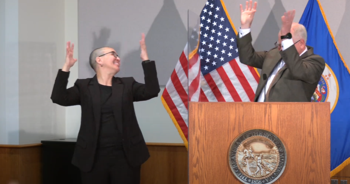 Nic Zapko and Gov. Tim Walz sign applause after the governor surprised her with a proclamation on her birthday.