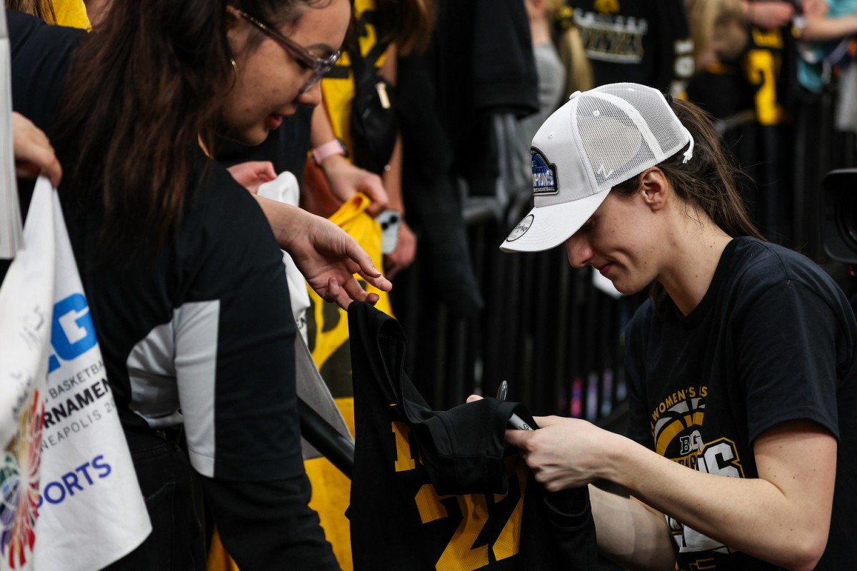 Mar 10, 2024; Minneapolis, MN, USA; Iowa Hawkeyes guard Caitlin Clark (22) signs autographs for fans after the game at Target Center. 